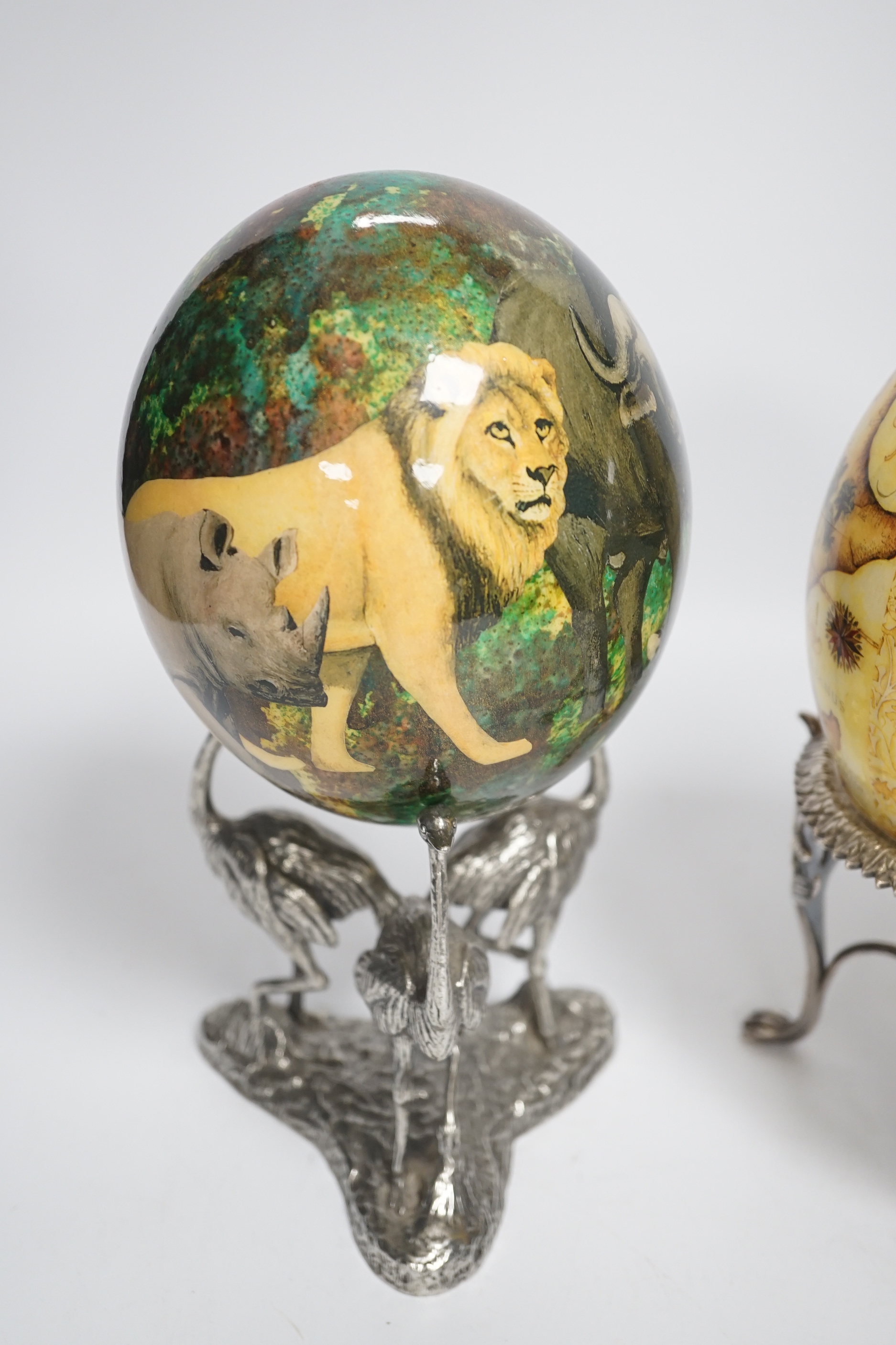 Two Julie Morgan ostrich eggs on plated ostrich stand, one by Elkingtons, 24cm high